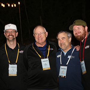 Four members smiling together at an evening welcome event