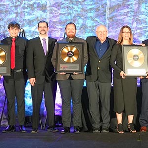 Award winners on stage holding their awards