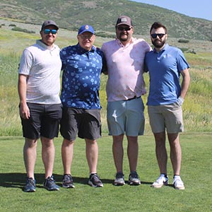 Four golfers posing together on the course
