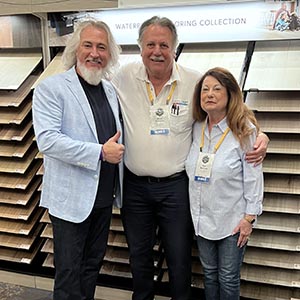 Members posing in front of a waterproof flooring display
